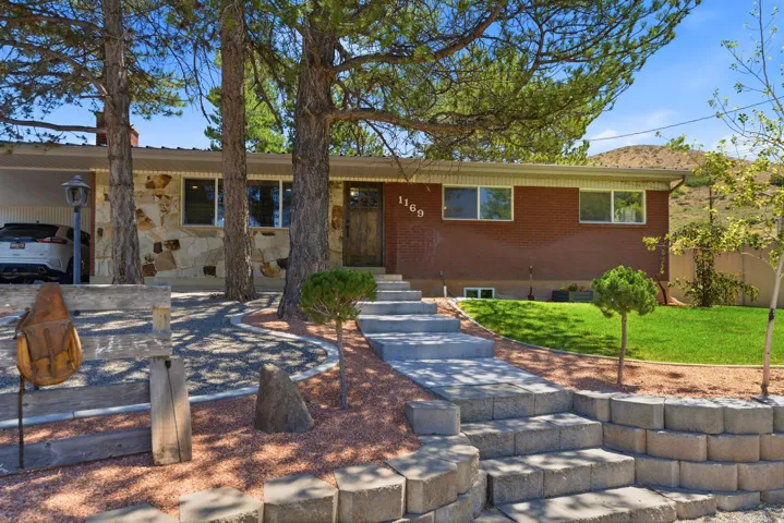 Ranch-style residence featuring a brick facade and natural stone accents