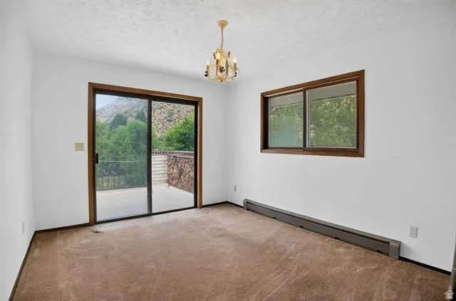 Interior space featuring warm-toned carpeting, a sliding glass door with a dark wood-finish frame, and a corresponding dark wood-finish framed window