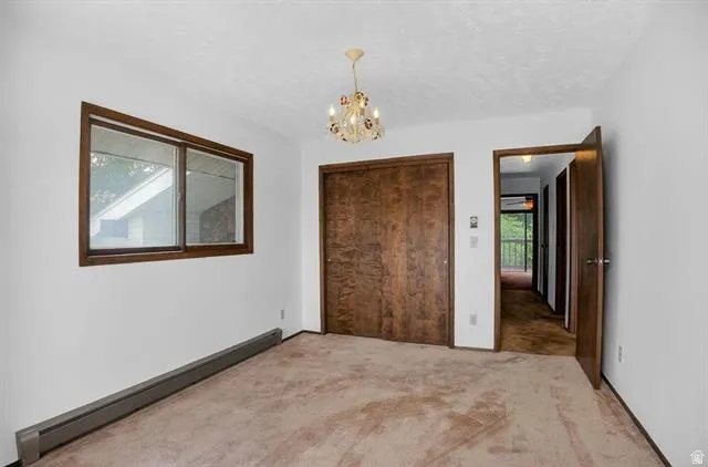 Spacious room featuring neutral carpeting and white walls