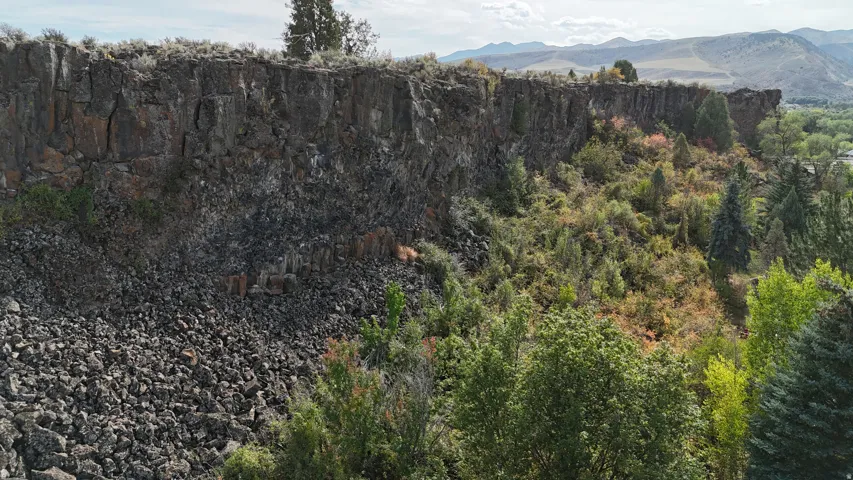 Rocky cliff face featuring natural rock formations and varied vegetation