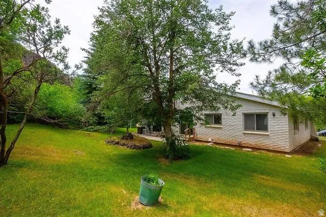 Expansive lawn area featuring mature trees and established landscaping