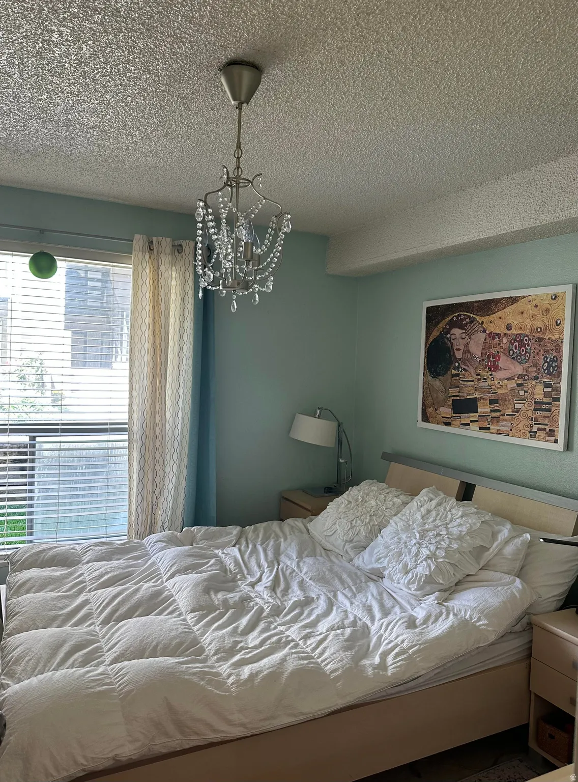 Room featuring a crystal chandelier, light-toned walls, and window with blinds