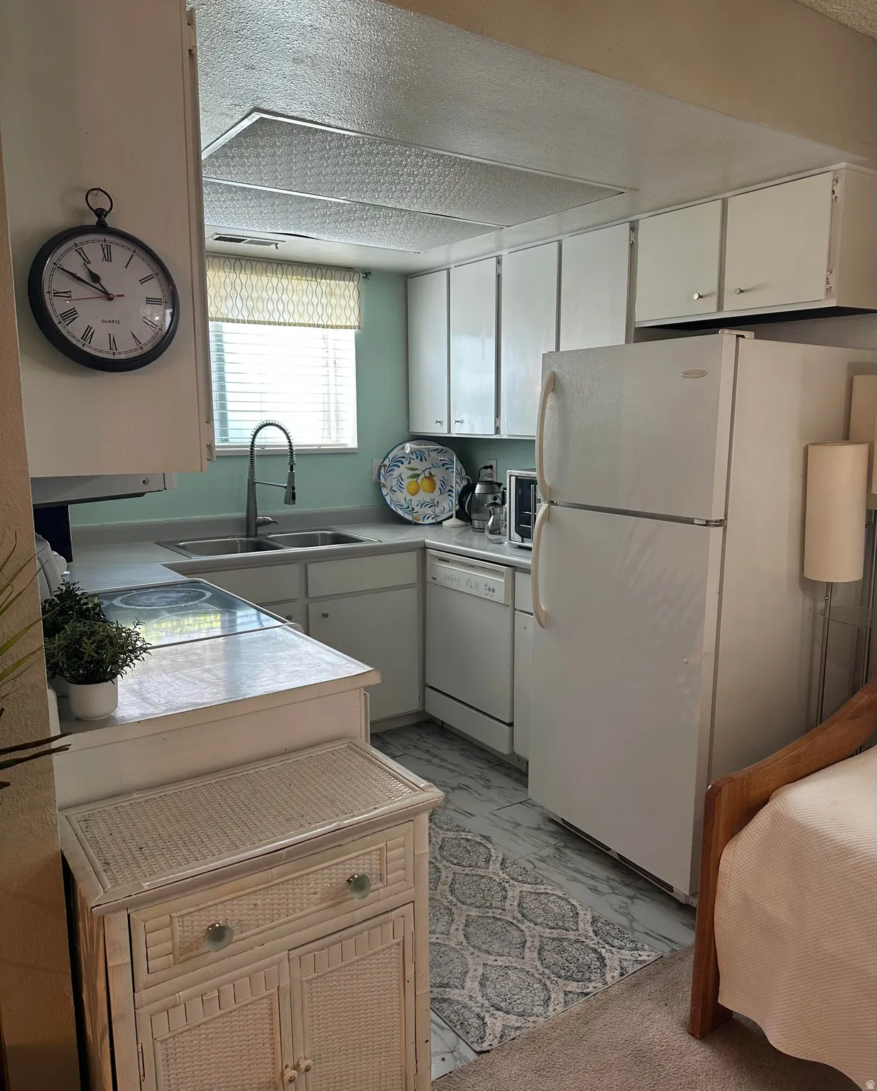 Kitchenette featuring white cabinetry, a double basin sink, and white appliances