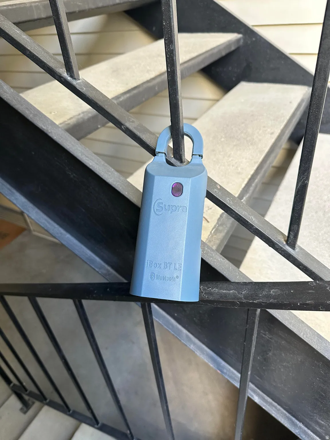 Supra key box on railing near front door