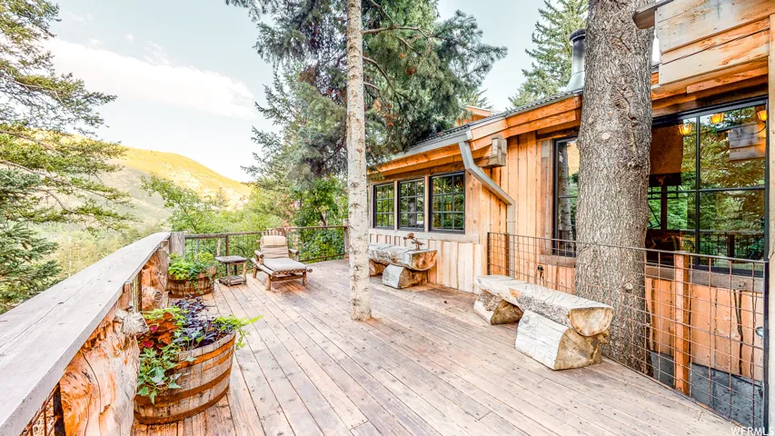 Expansive wood-finish deck bordered by a rustic log railing