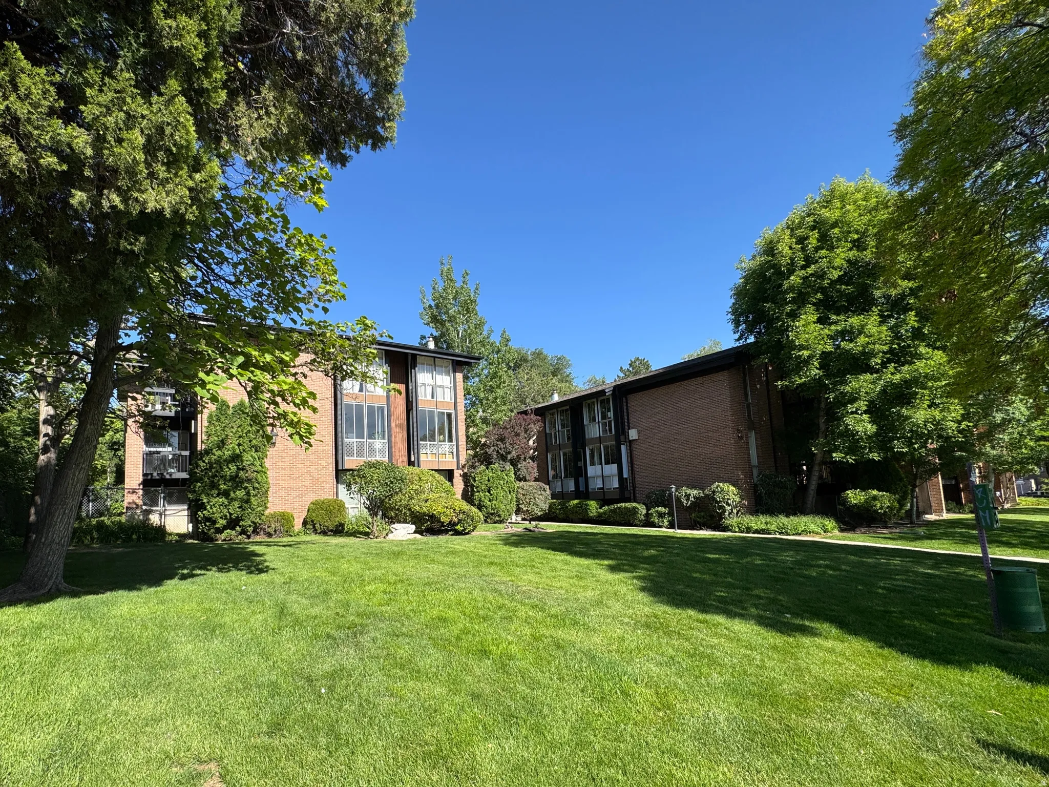 Expansive lawn area featuring mature trees and established landscaping