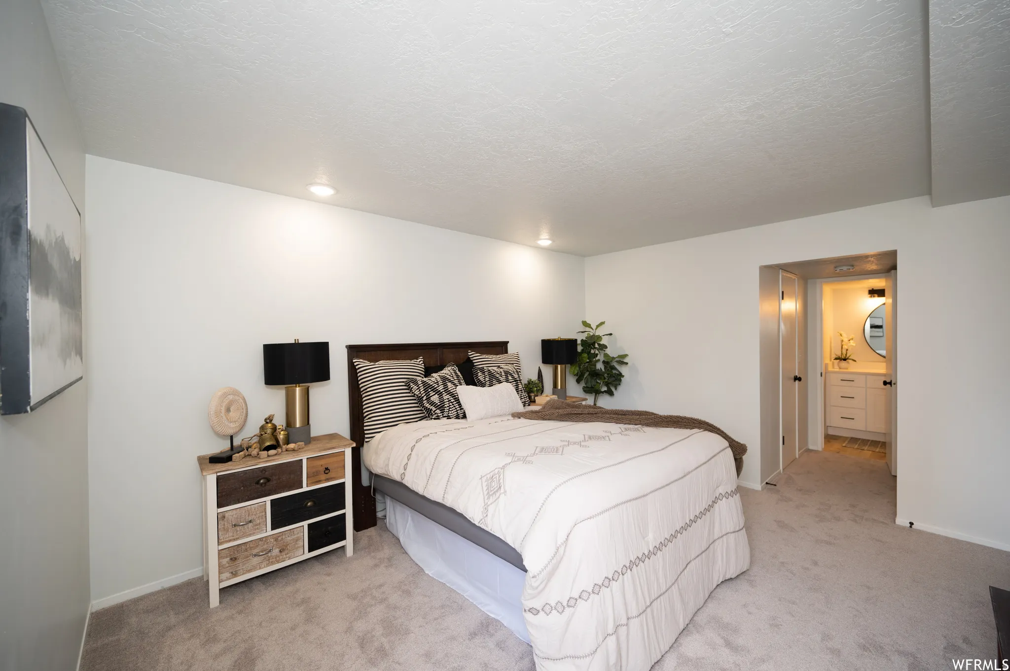 Spacious bedroom featuring light-toned carpeting and recessed lighting