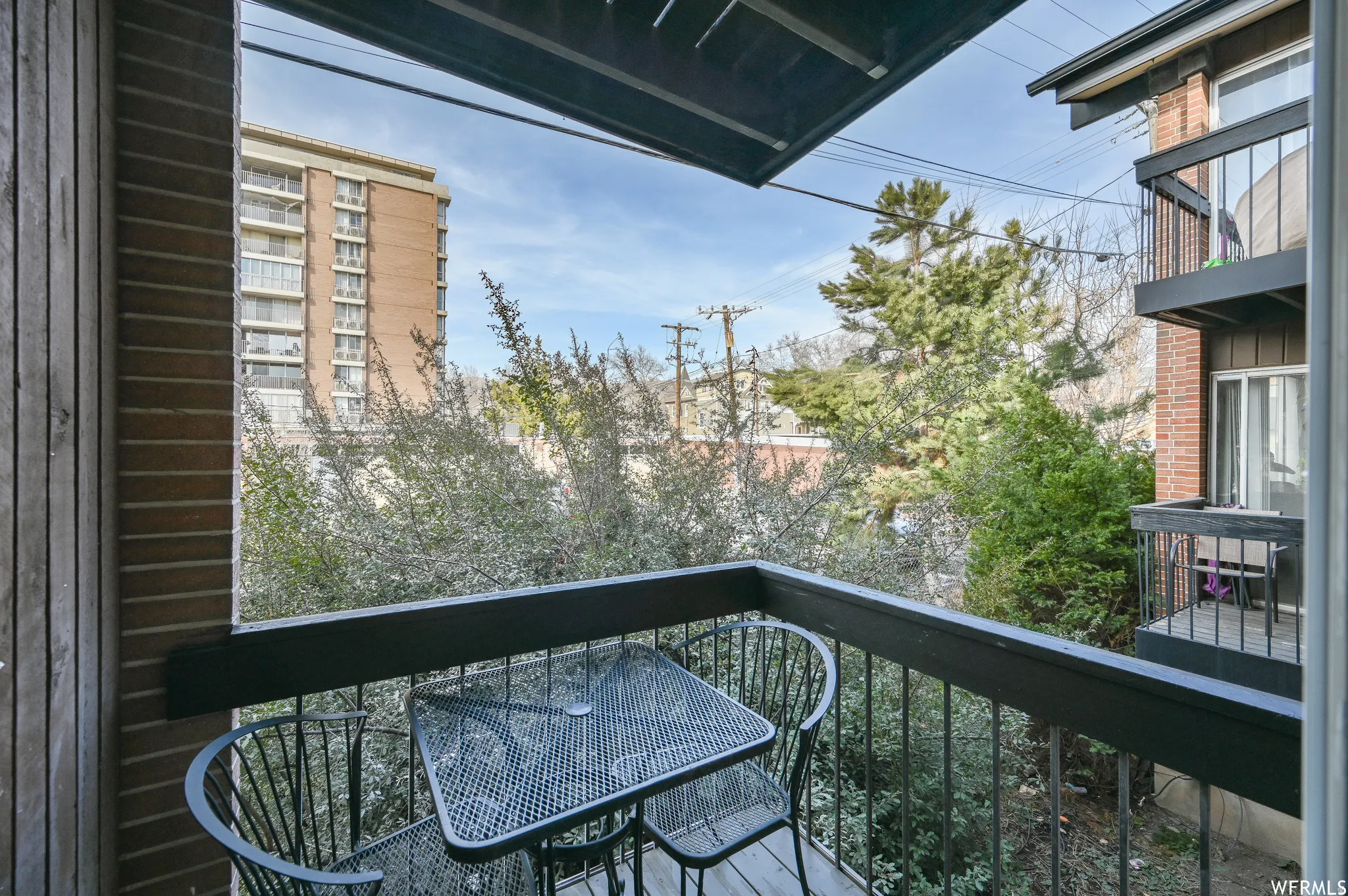 Private outdoor balcony with wood-finish siding and black metal railings