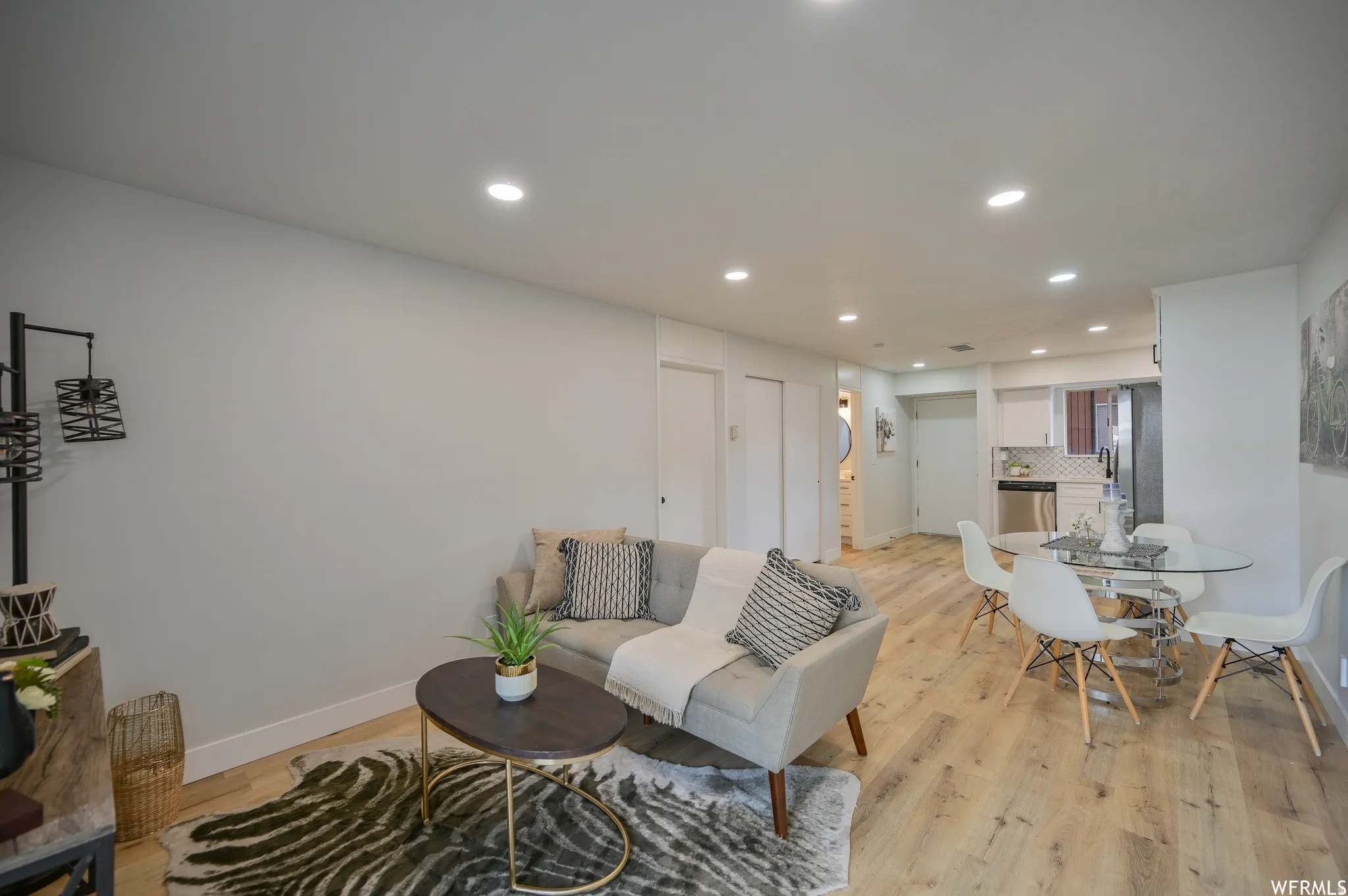 Open-concept living area featuring wood-finish flooring, recessed lighting, and a neutral color palette