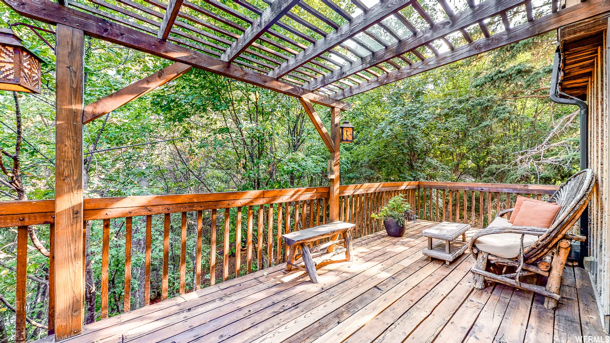 Expansive wooden deck with a slatted pergola overhead