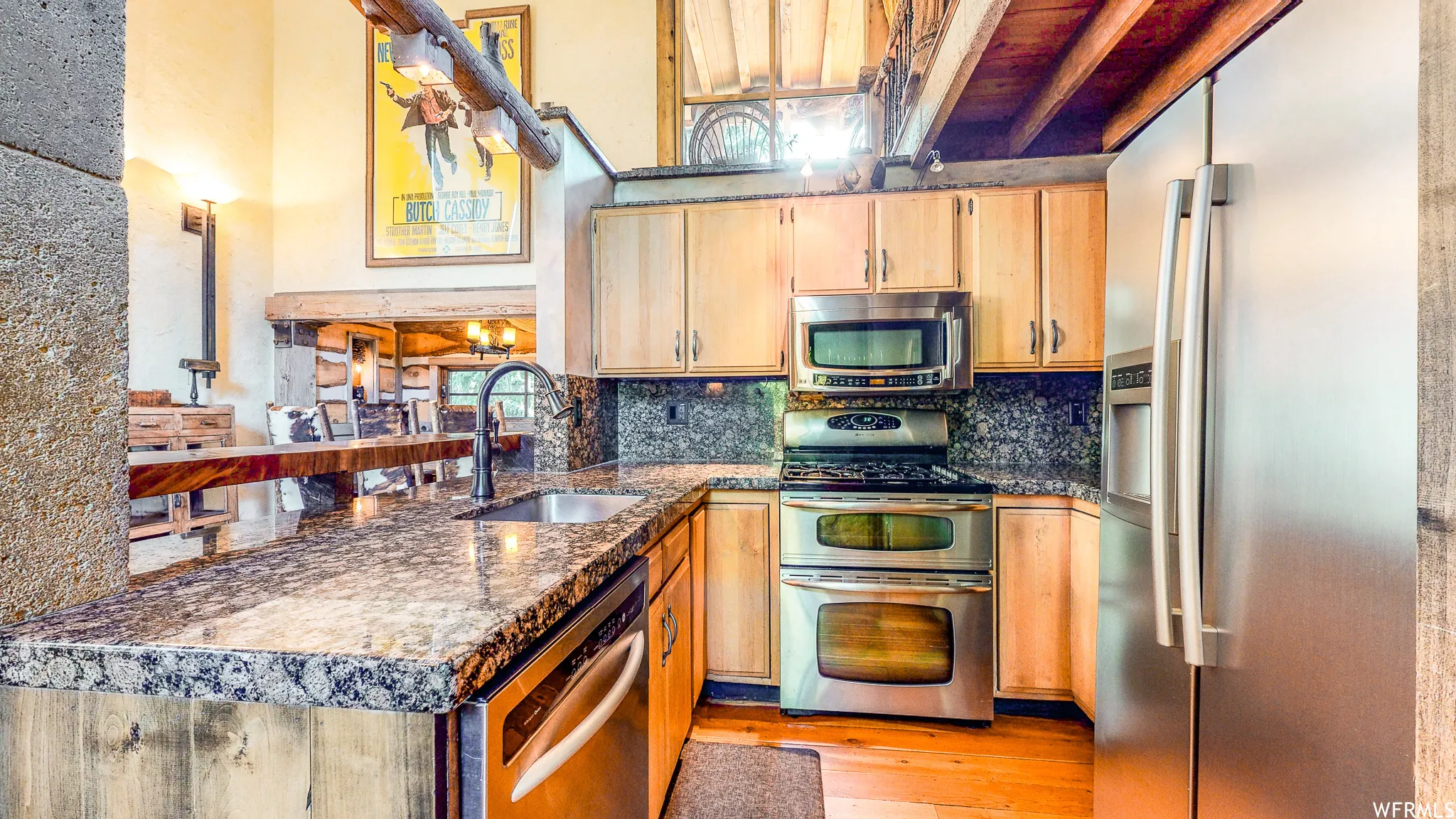 Kitchen featuring stone-finish countertops, stainless steel appliances, light wood cabinetry, a built-in microwave, and a double oven