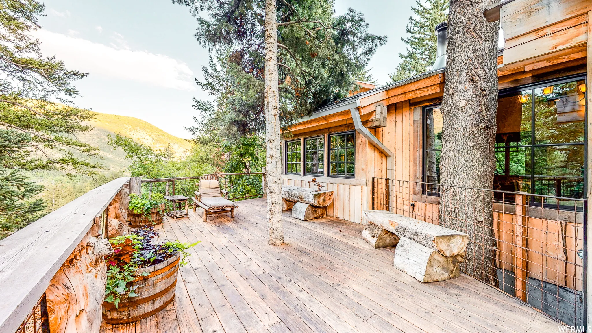 Expansive wood-finish deck bordered by a rustic log railing