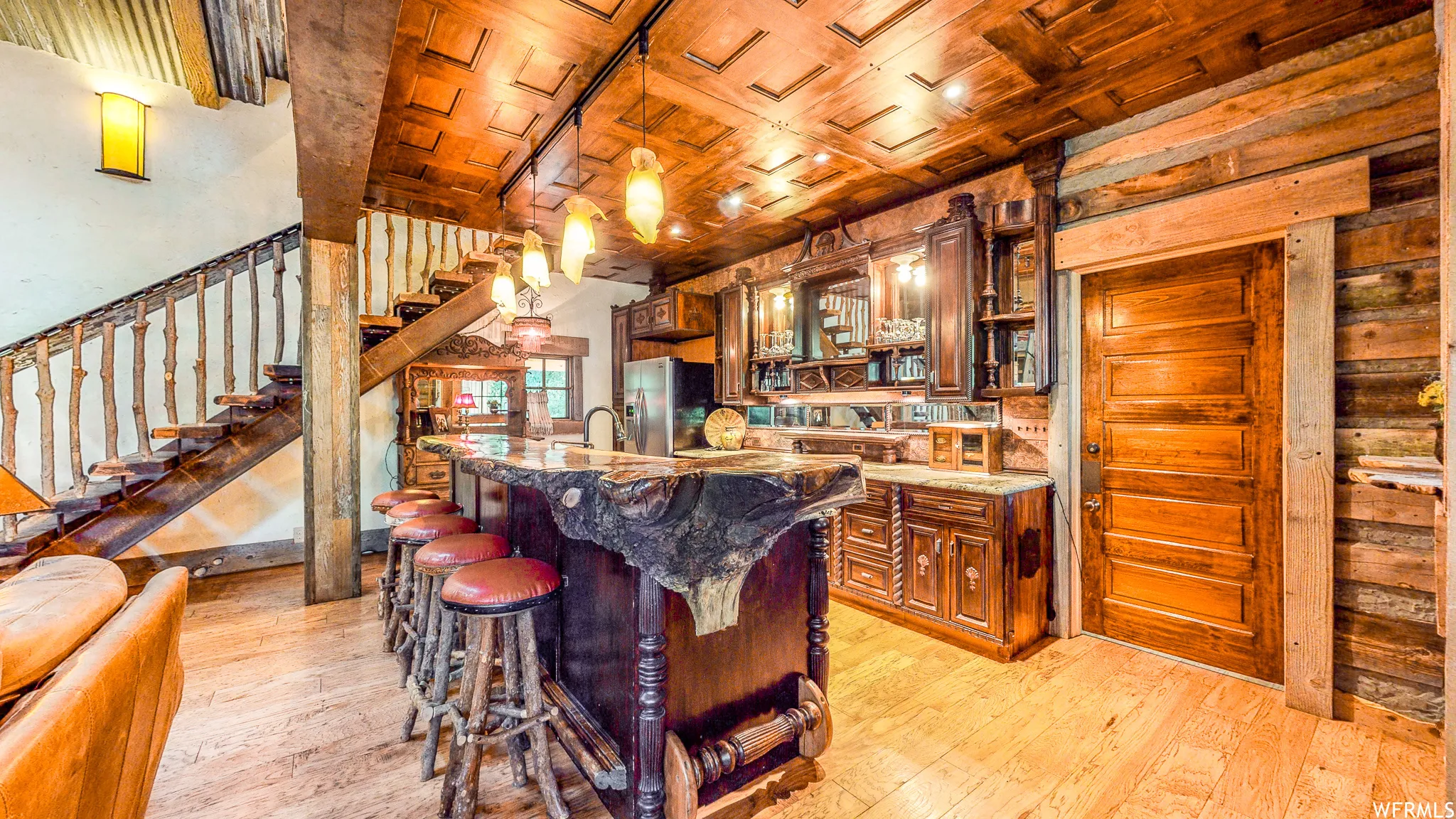 Rustic-inspired interior featuring a live-edge bar with integrated seating, wood-finish flooring, and a unique wood plank ceiling