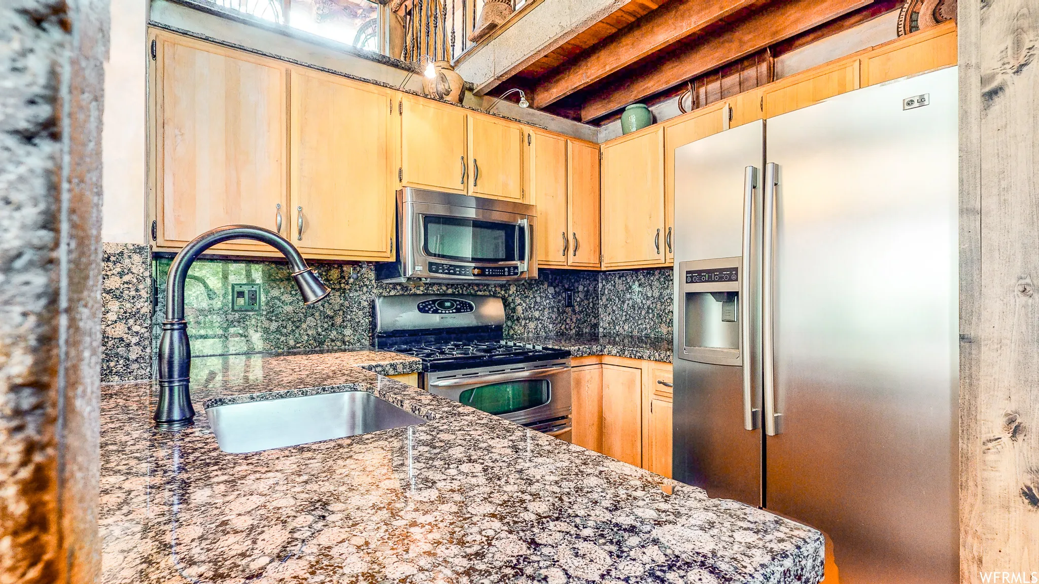 Kitchen featuring granite countertops, wood cabinetry, stainless steel appliances, and a built-in range with a microwave