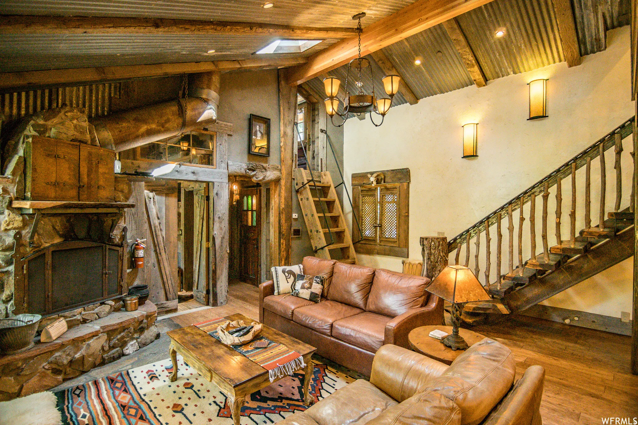 Stone-clad fireplace with a hearth, wood-finish flooring, and exposed corrugated metal ceiling