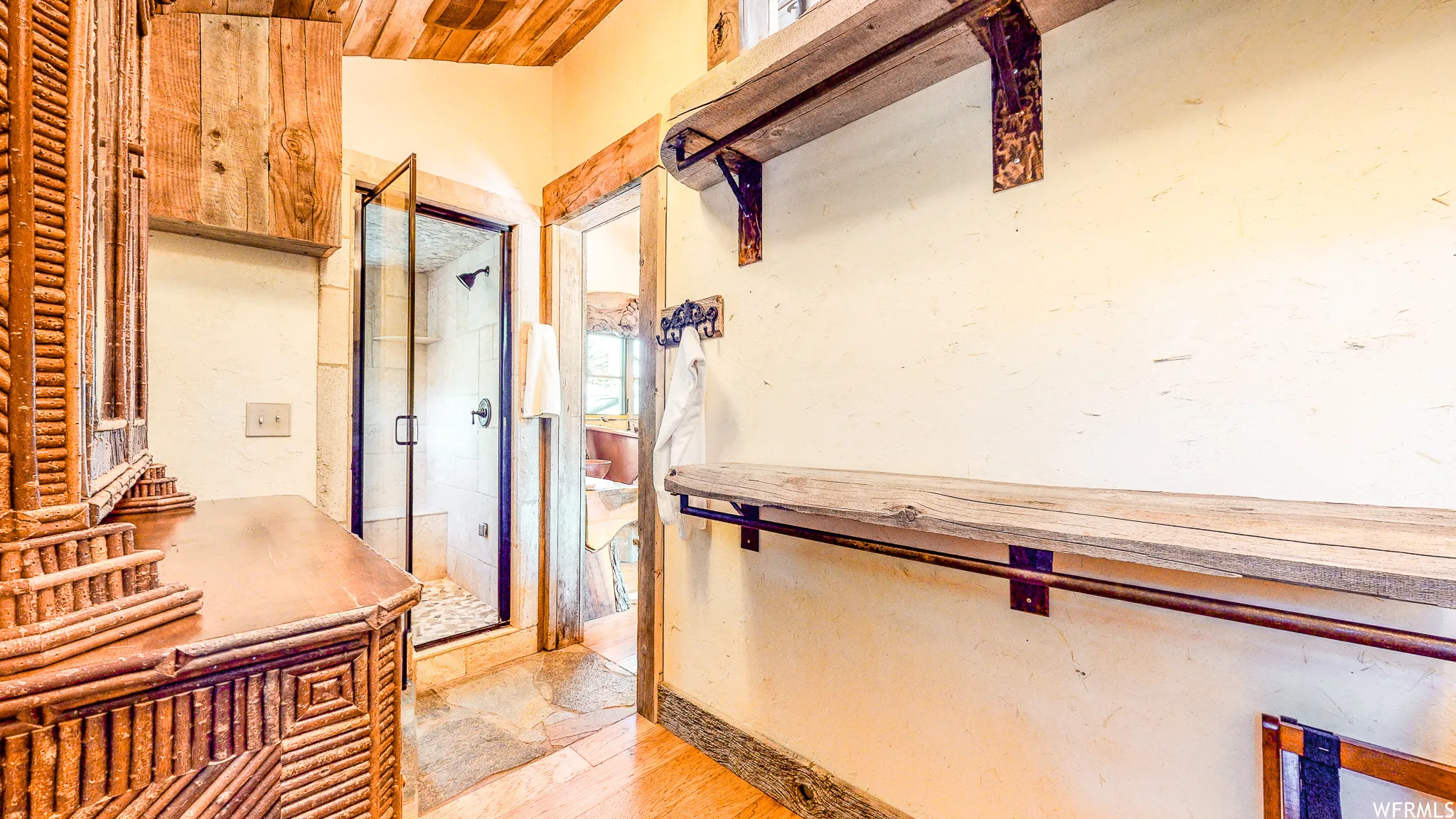 Walk-in shower with clear glass enclosure and stone-look tile