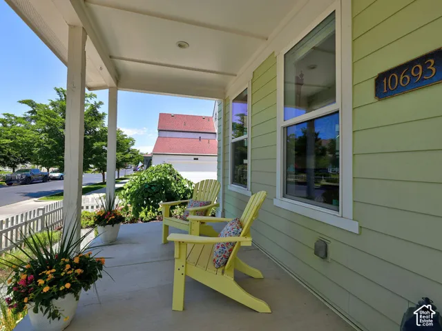 Inviting covered front porch with a concrete surface and white support columns