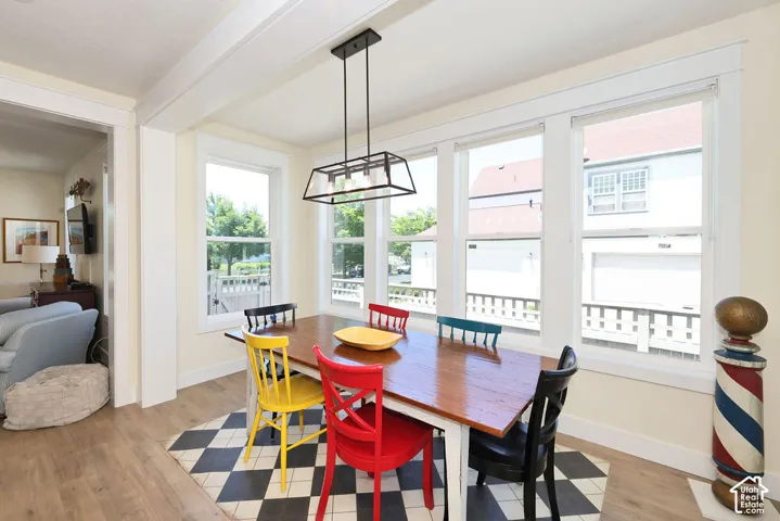 Dining area featuring light wood-finish flooring, a coffered ceiling, and a linear pendant light fixture