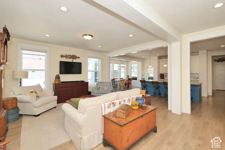 Expansive living area featuring light-tone wood-finish flooring, recessed lighting, and bright white trimwork