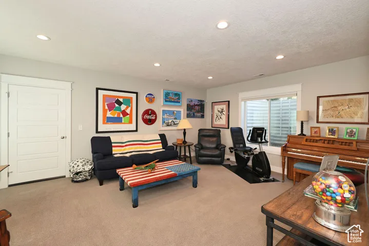 Spacious room with recessed lighting and neutral-toned carpeting