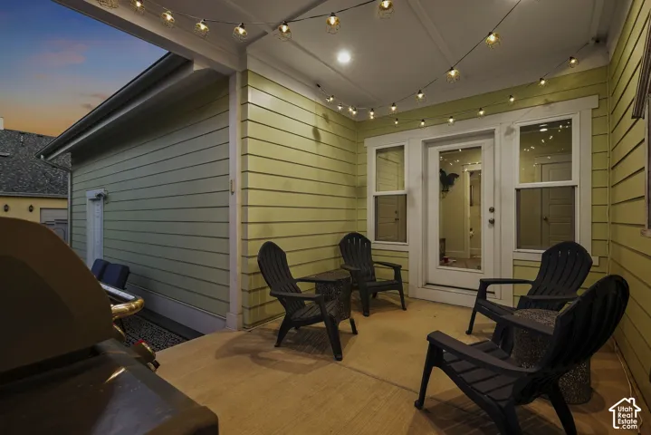 Covered outdoor patio with string lighting and a light green siding exterior