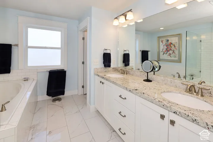Dual vanity featuring white cabinetry and granite countertops