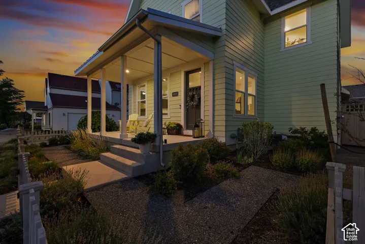 Inviting covered front porch with recessed lighting, concrete steps, and a walkway