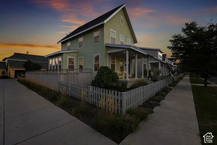 Two-story residence with a covered porch, wood siding, and gabled roofline
