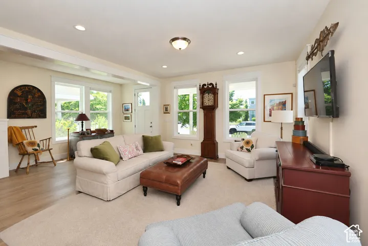 Recessed lighting, wood-finish flooring, white trim, and multiple windows