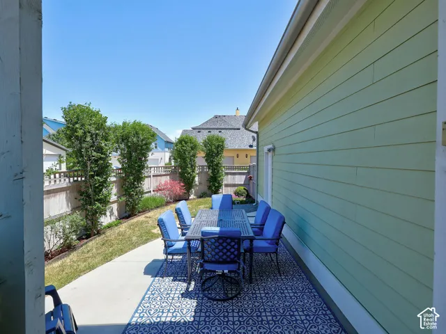 Concrete patio featuring a decorative outdoor rug with a blue and white pattern