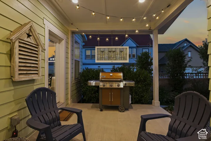 Covered patio with a concrete surface, overhead lighting, and wood-finish siding