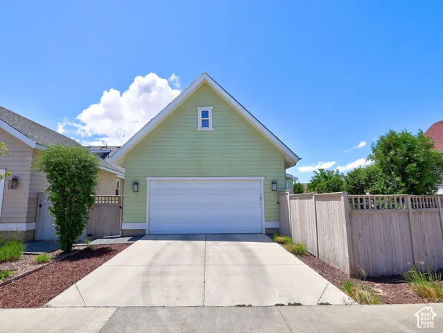 Light green siding with a white trim gable, featuring a single garage door and a rectangular window