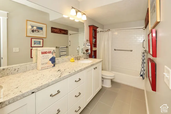 Bathroom featuring a spacious vanity with white cabinetry and a speckled countertop