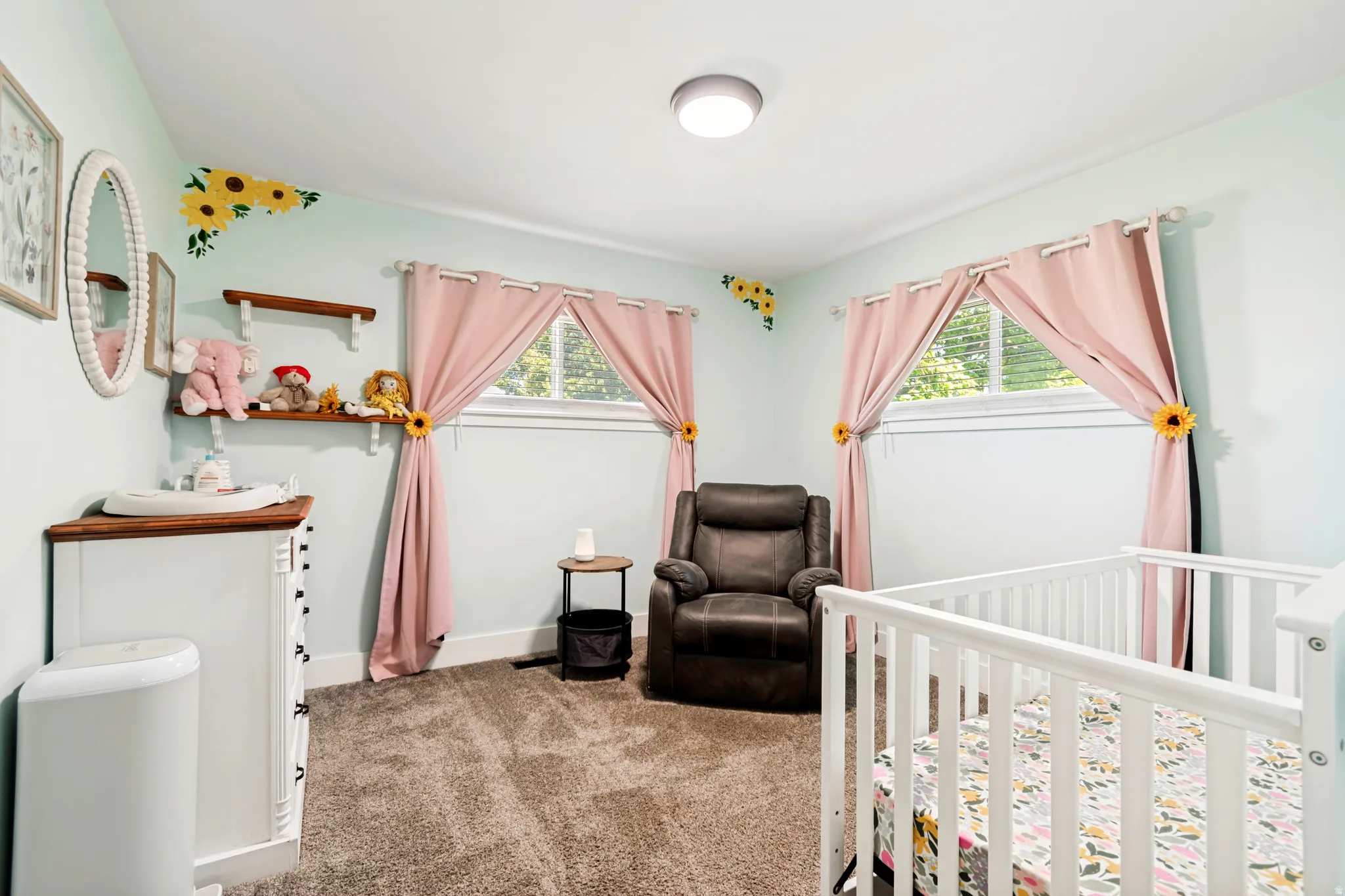 Light blue painted walls with two windows featuring white trim and two floating wood shelves