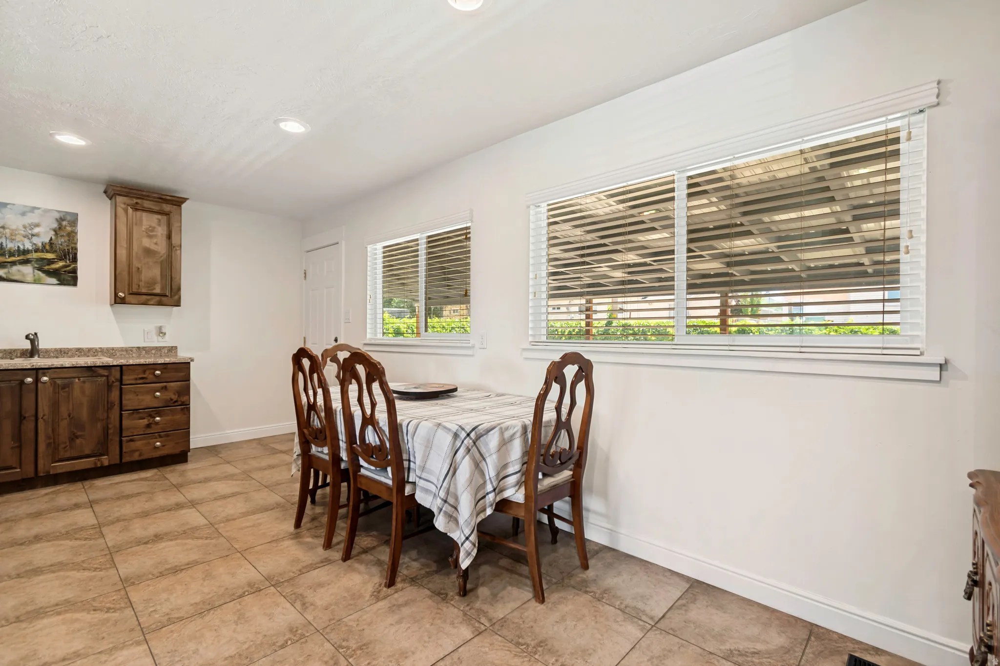 Kitchenette featuring wood cabinetry with a built-in sink, stone-finish countertops, and recessed lighting