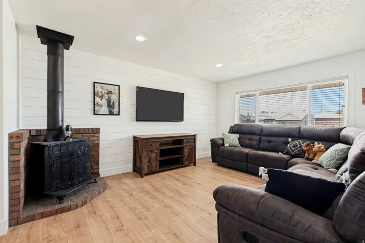 Living area featuring a brick hearth and a black wood-burning stove with a stovepipe