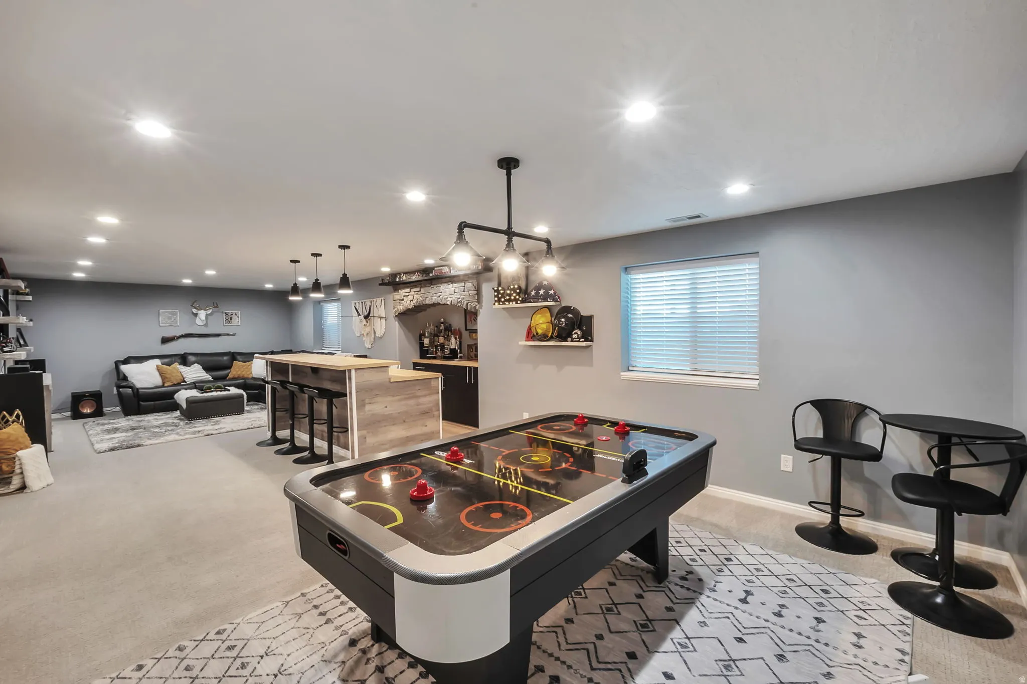 Spacious recreational room featuring recessed lighting and a window with blinds