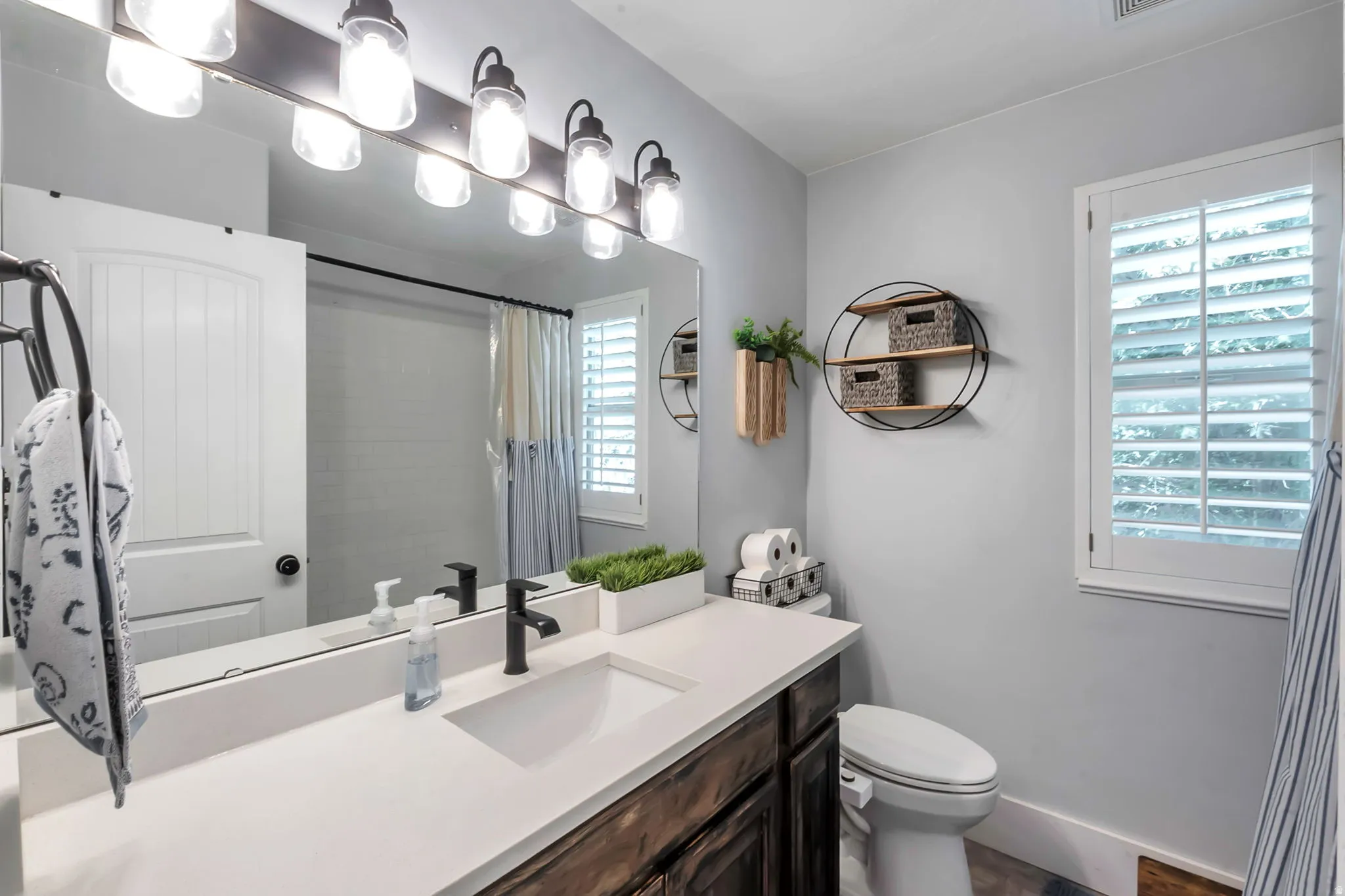 Bathroom featuring an expansive vanity with a white countertop and integrated rectangular sink