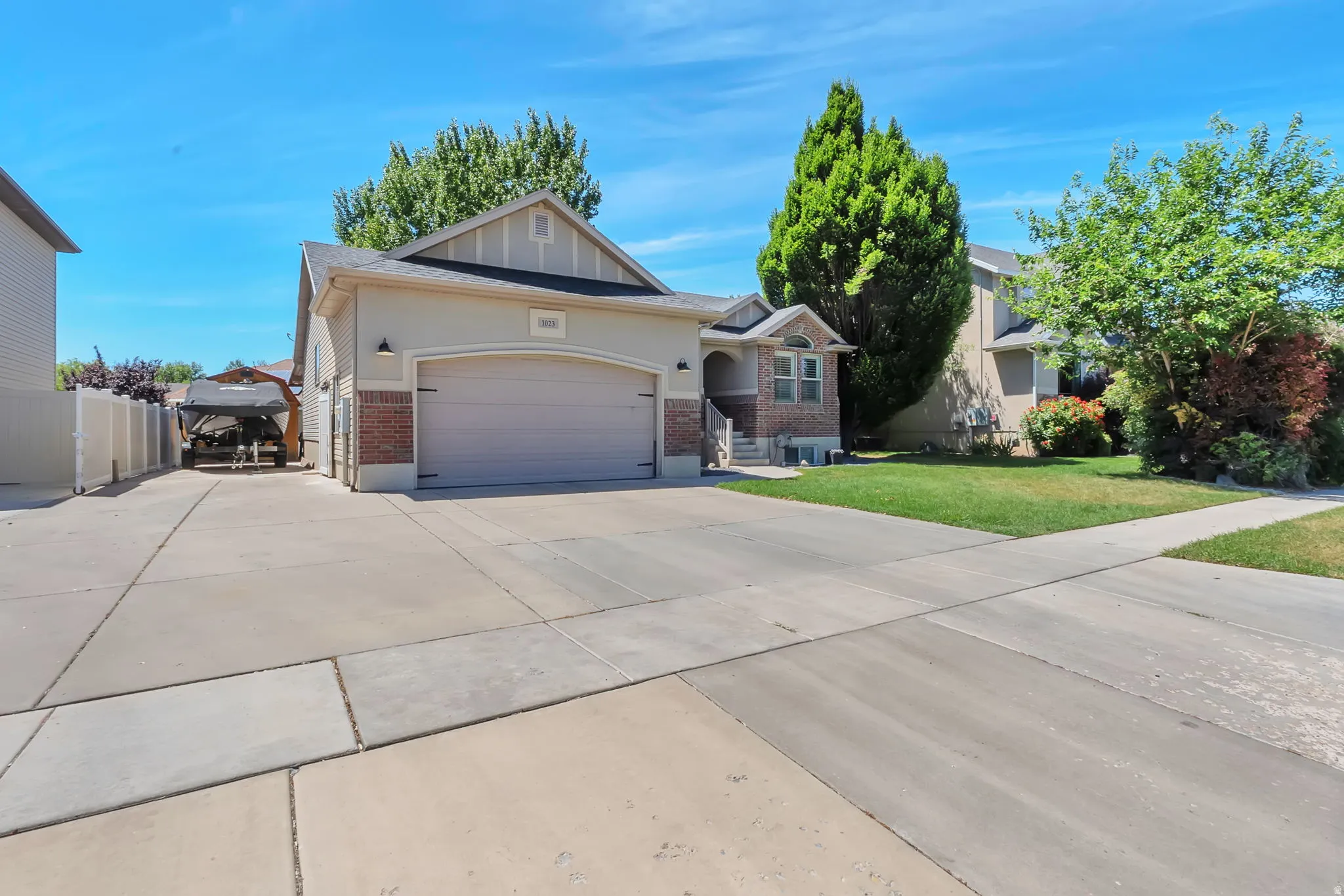 Single-story residence featuring a two-car garage, partial brick facade, and a concrete driveway