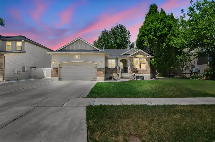 Single-story residence featuring a brick and stucco exterior, an arched entry, a two-car garage, and a concrete driveway
