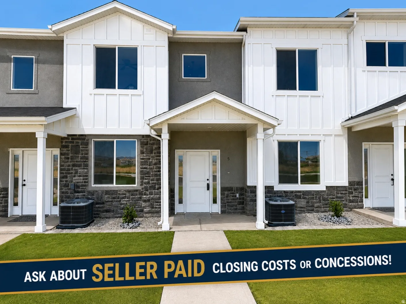 Modern townhome exterior featuring an inviting covered porch, contemporary board and batten siding, stone facade accents, and a manicured lawn