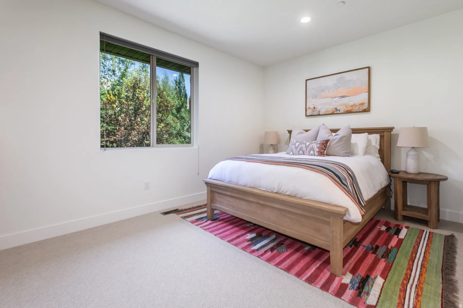 Bright bedroom with a large window and forest scenery
