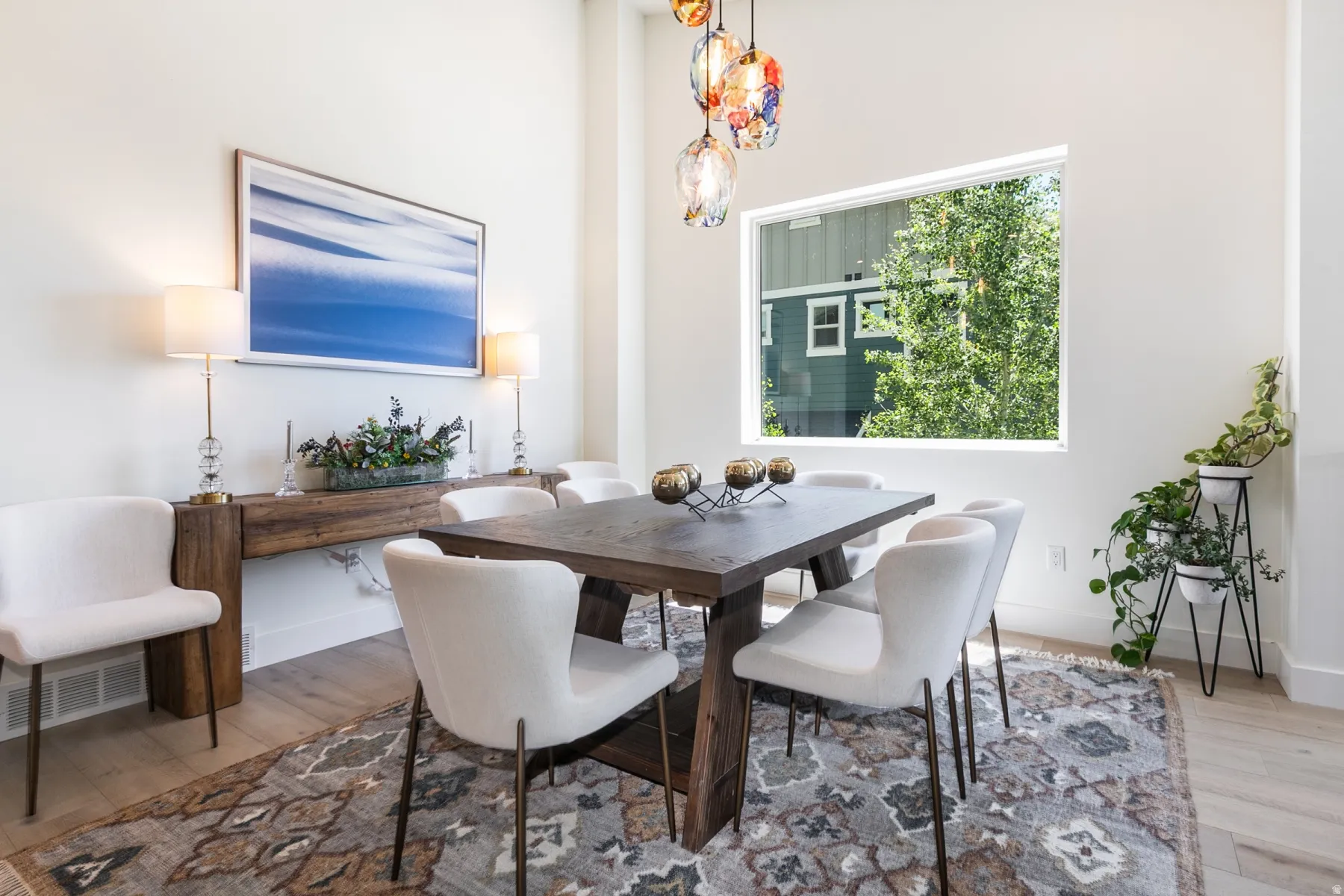 Dining area featuring high ceilings, wood-finish flooring, and a large picture window
