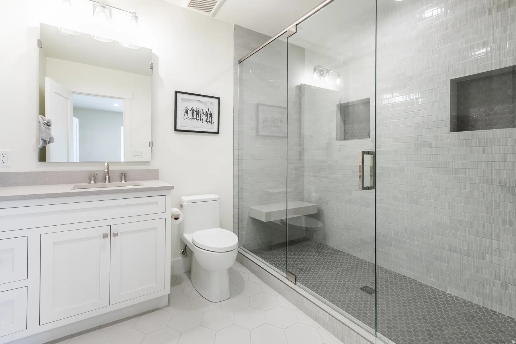 Modern bathroom featuring a glass-enclosed shower with subway tile surround and integrated bench