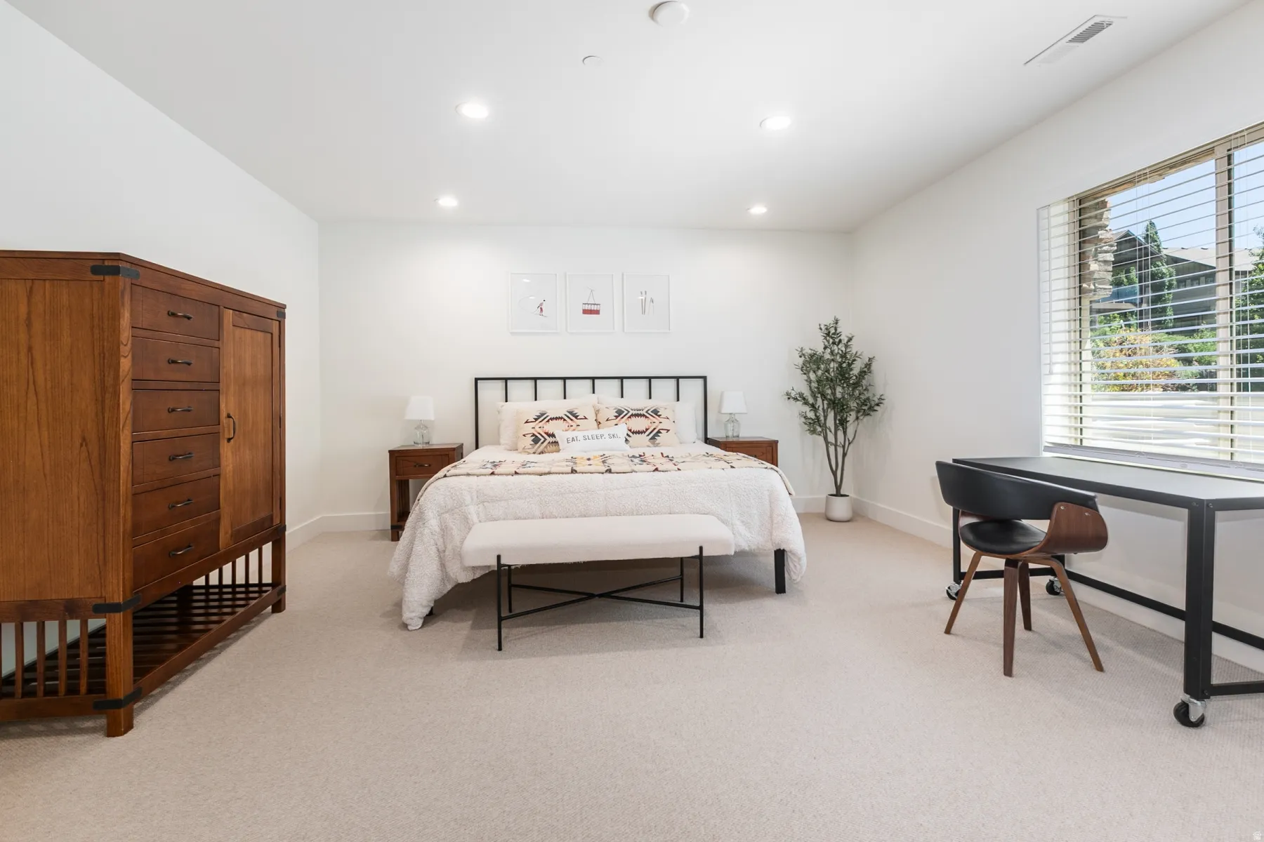 Spacious room featuring neutral carpeting, white walls, recessed lighting, and a large window with horizontal blinds