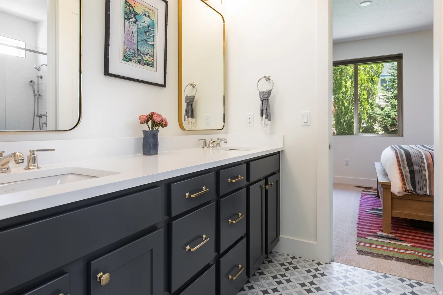 Double vanity with dark cabinetry, brass hardware, under-mount sinks, and a white countertop