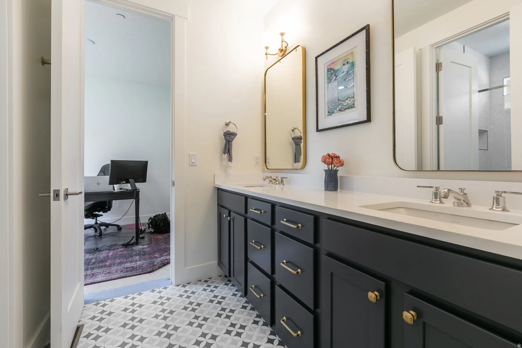 Dual vanity featuring dark cabinetry with brass hardware, a white countertop, and rectangular undermount sinks