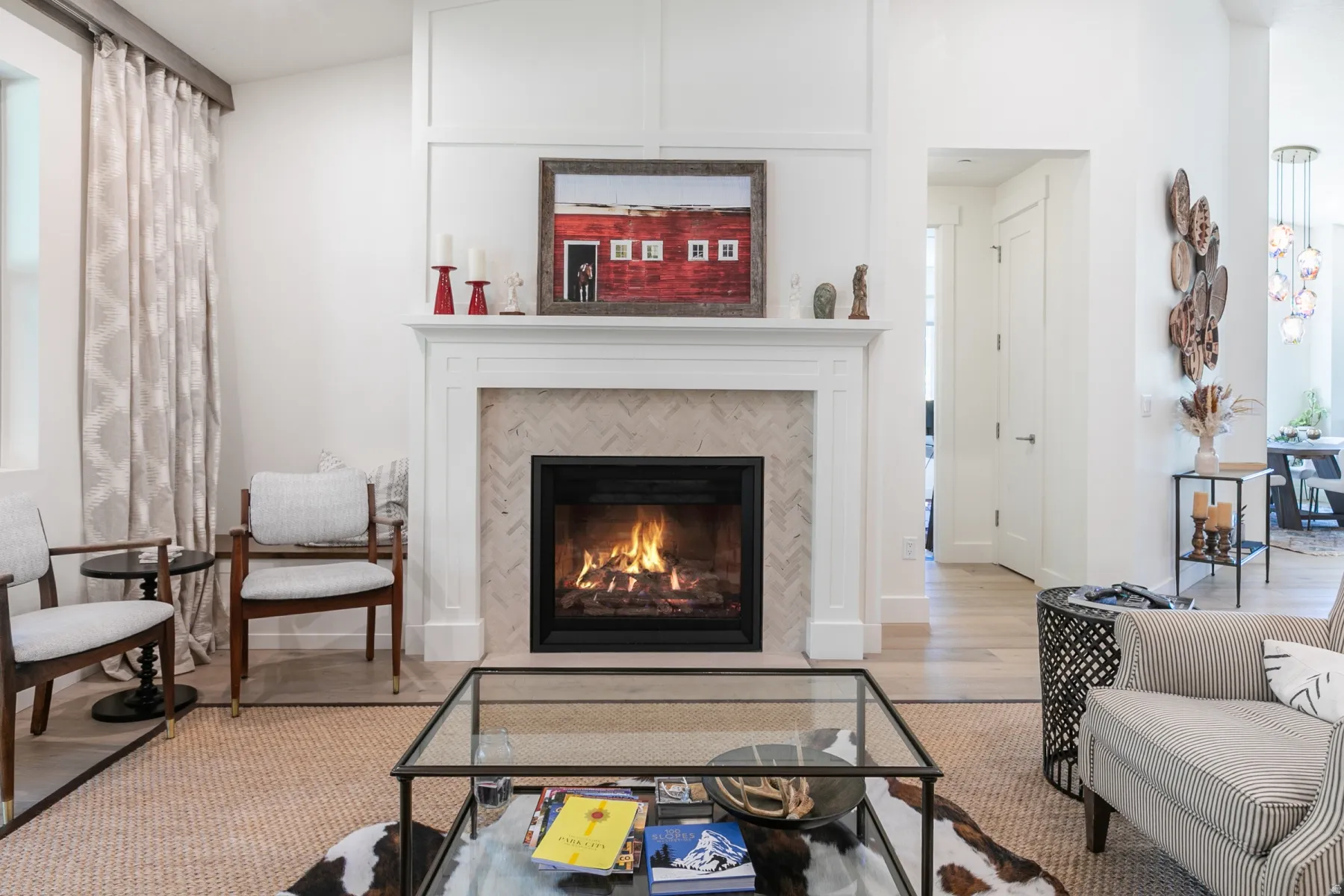 Living area featuring a fireplace with a herringbone tile surround and traditional white mantel