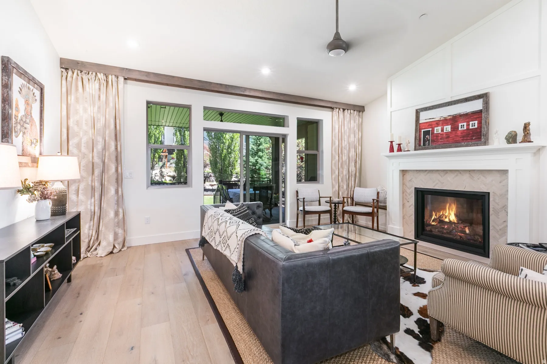Living area featuring a fireplace with a herringbone tile surround and a substantial white mantel