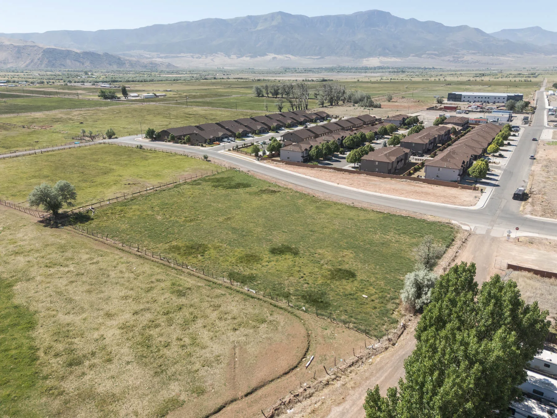 Expansive open land with a distinct treeline and mountain backdrop